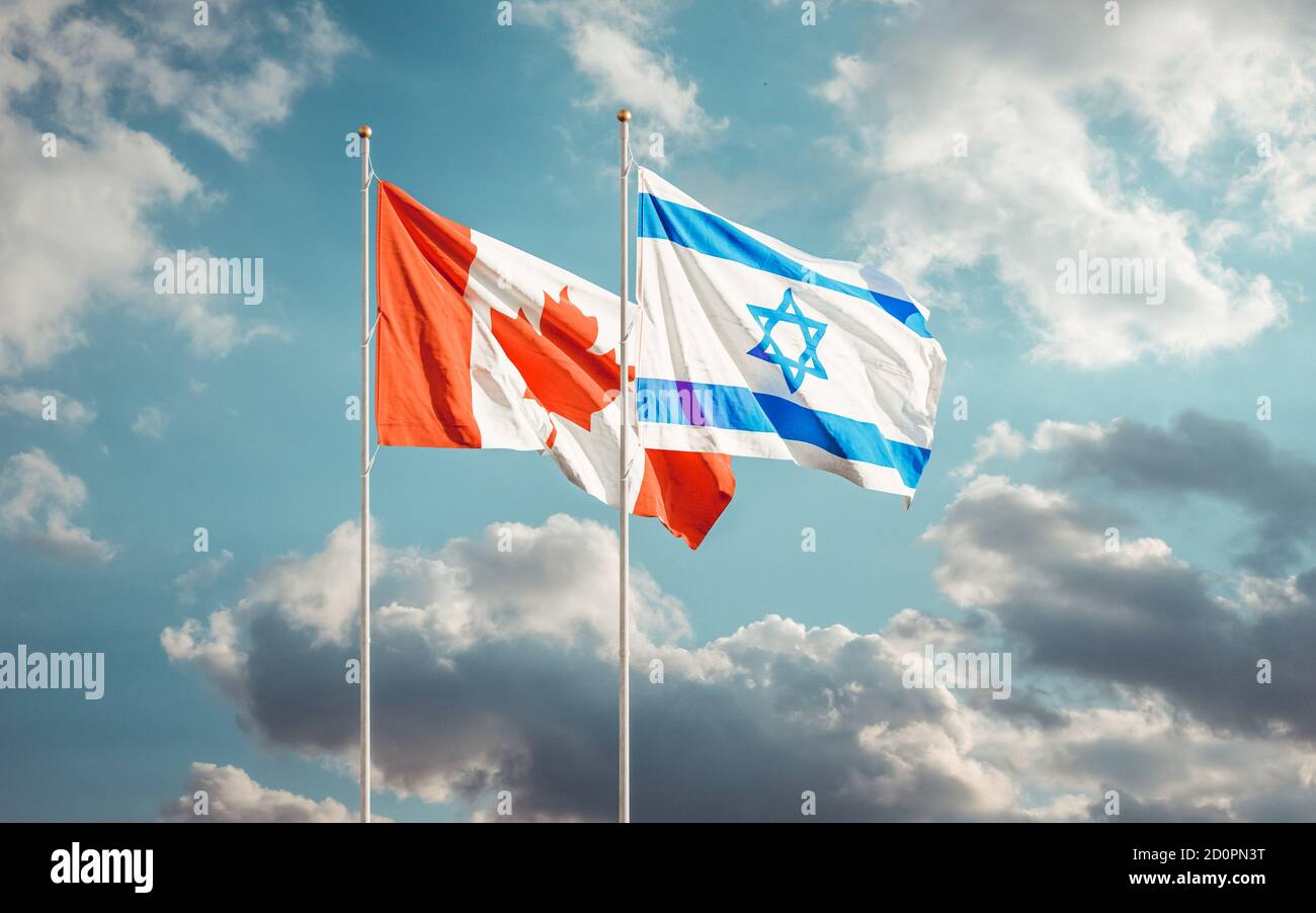 Bandiere di Canada e Israele che sventolano sullo sfondo del cielo nuvoloso. Concetto di relazioni internazionali canadesi israeliane. Foto Stock