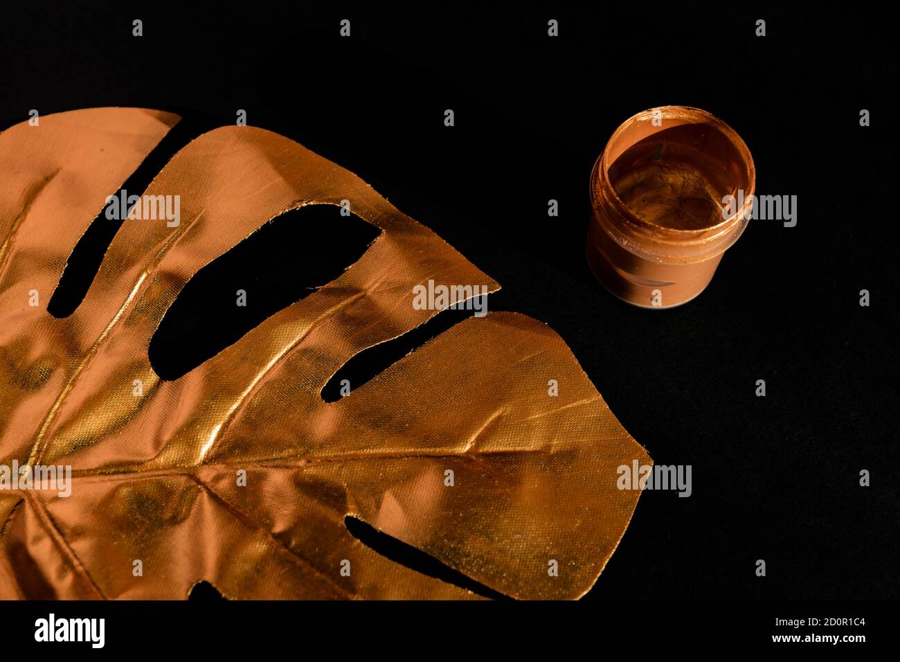 Foglia di monstera di palma dipinta in oro su sfondo nero Foto Stock