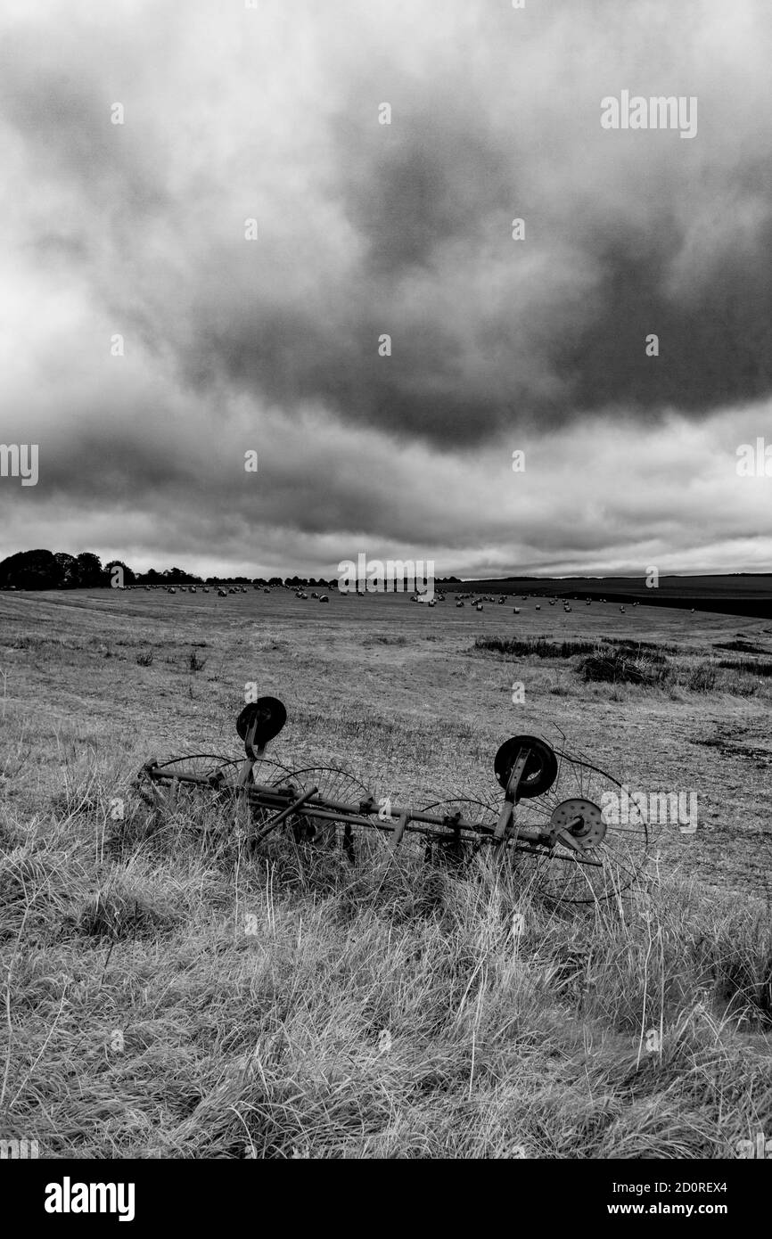 Un vecchio foraggio di fieno, o filatore, sulle colline sopra la città di Mere Wiltshire, in una giornata umida e ventosa come Storm Alex arriva. conv. Fotografia digitale a colori Foto Stock