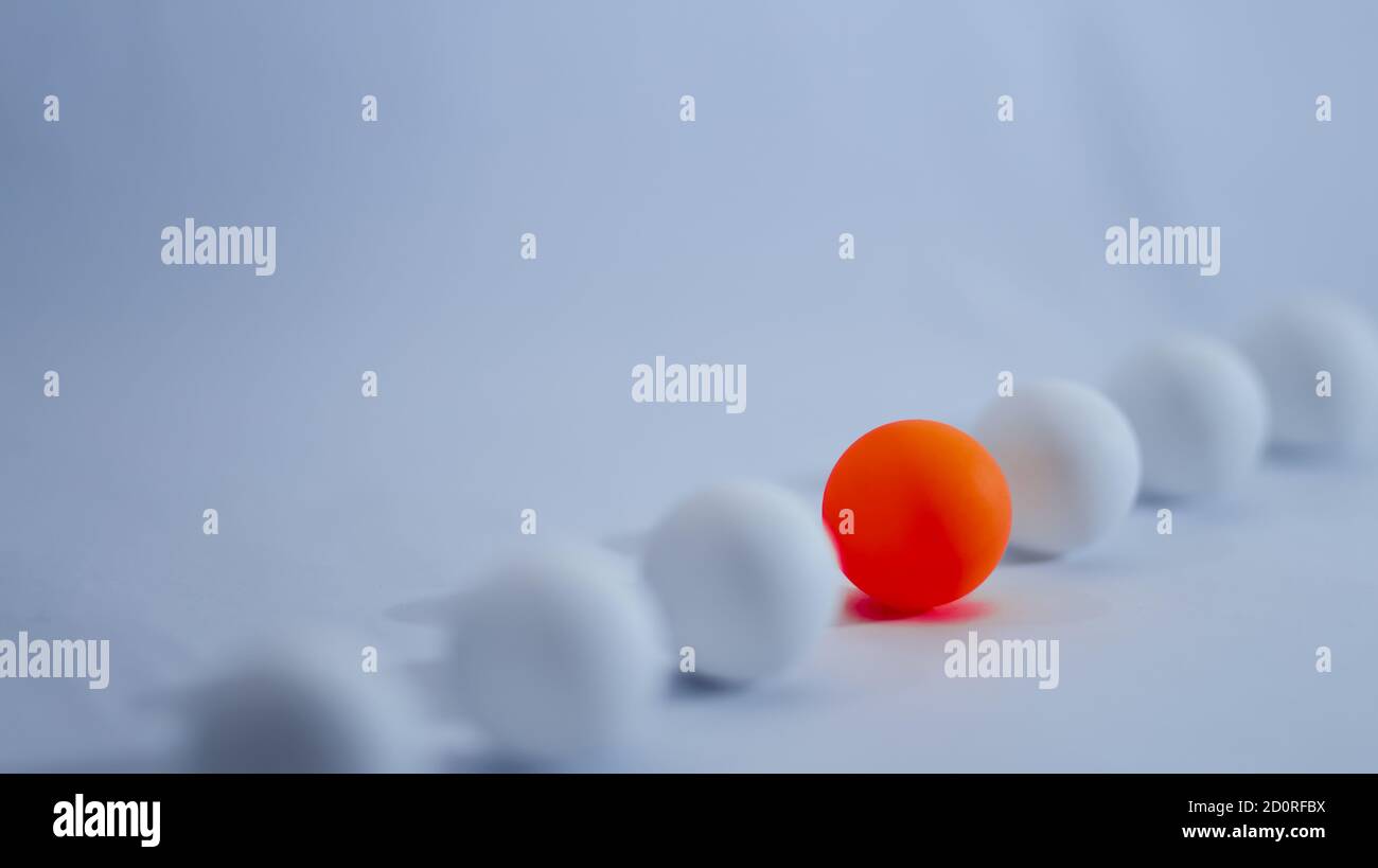 Foto concettuale diversa. Una sfera arancione si allinea con la sfera bianca con sfondo chiaro Foto Stock