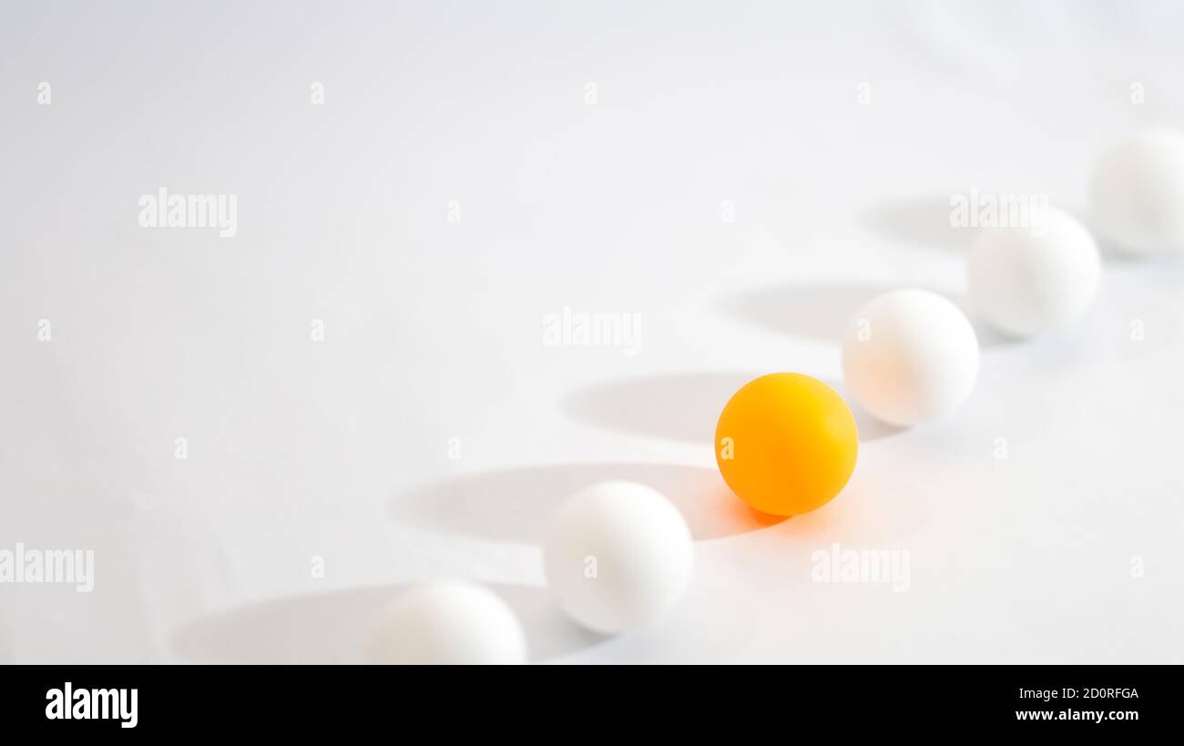 Foto concettuale diversa. Una sfera arancione si allinea con la sfera bianca con sfondo chiaro Foto Stock