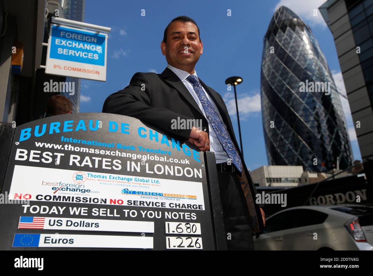 Il direttore Sakthi Ariaratnam pone fuori da una filiale di Thomas Exchange Global Foreign Exchange nella città di Londra 1 luglio 2014. Da un piccolo seminterrato bianco vicino alla stazione di Liverpool Street di Londra, Ariaratnam batte le banche a quello che avreste pensato fosse il loro gioco, ed è relativamente facile. In una recente mattinata di martedì nel cuore del quartiere finanziario di Londra, la ditta Sakthi's Best FX vi venderebbe 124 euro per 100 sterline britanniche. A meno di 20 metri lungo la strada, il terzo commerciante mondiale di valute estere, Barclays, vi darebbe solo 118. Fotog Foto Stock