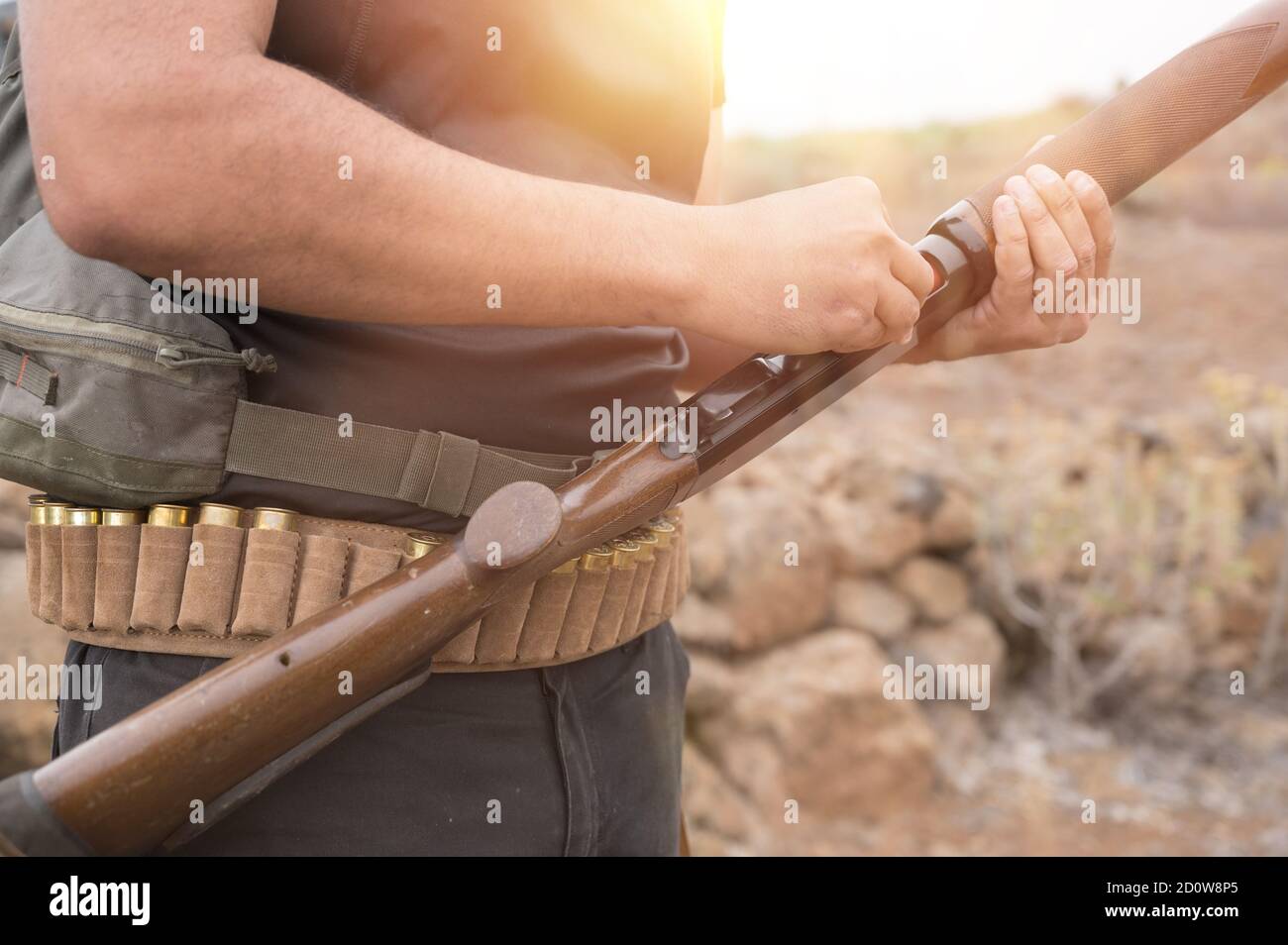 Primo piano di un cacciatore irriconoscibile, caricando fucile da caccia, tiene in mano un fucile da caccia e munizioni. Foto di alta qualità Foto Stock