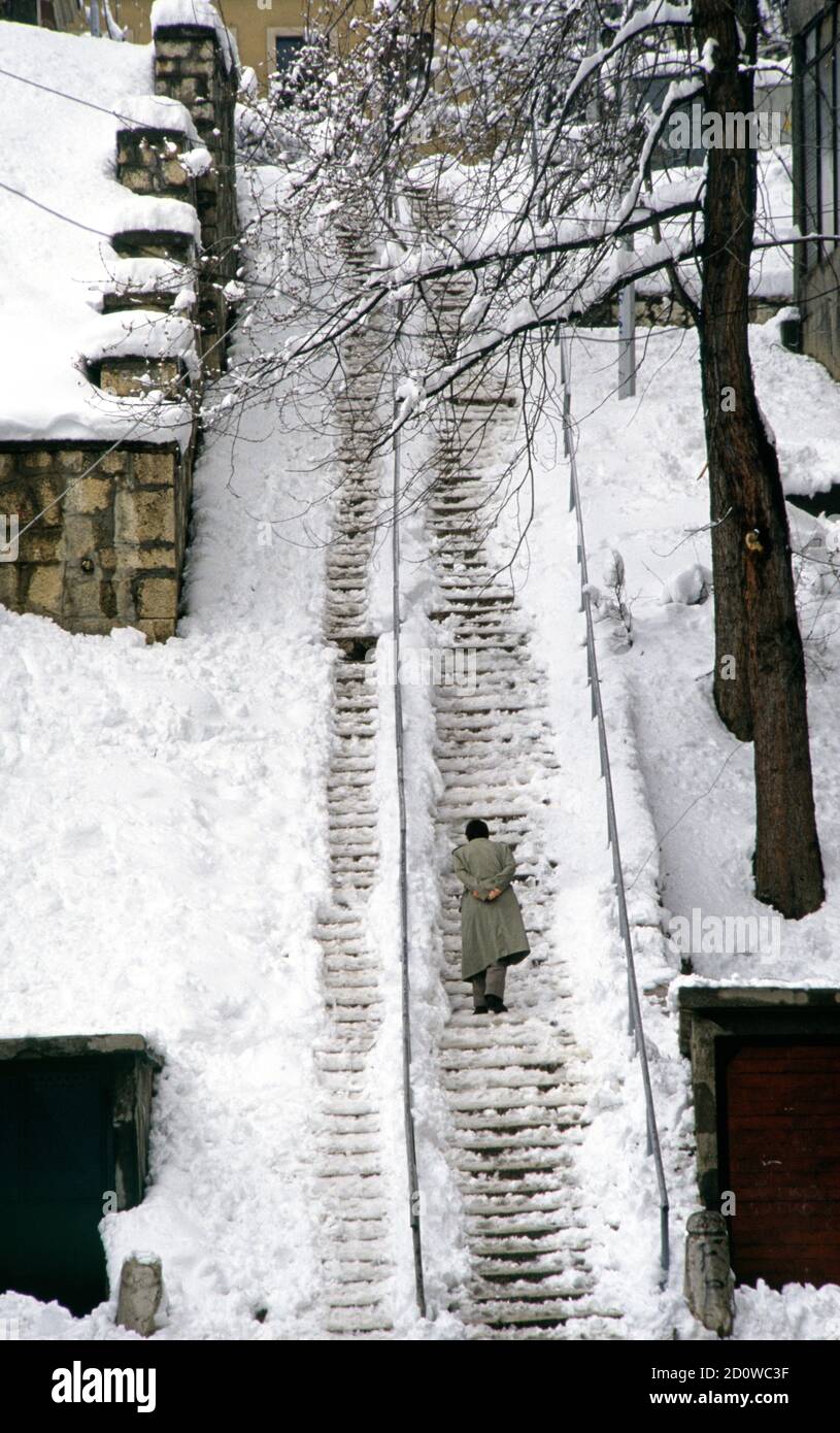 Il 28 marzo 1993 durante l'assedio di Sarajevo: su Ilije Grbica (oggi chiamato Nize Banje), un uomo si arrampica una lunga serie di coperte di neve passi. Foto Stock