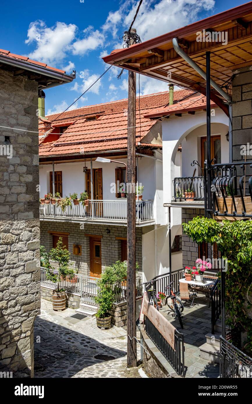 Vista ad alto angolo di Spring Street, balcone con colorati fiori in vaso e cielo dalla città di Metsovo, Epiro, Grecia. La struttura è popolare stazione sciistica invernale greca con vecchie case in stile balcanico Foto Stock