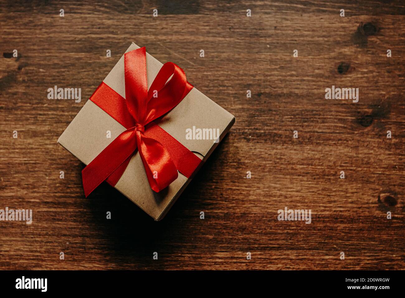 regalo la scatola di cartone è decorata con un regalo rosso nastro Foto Stock