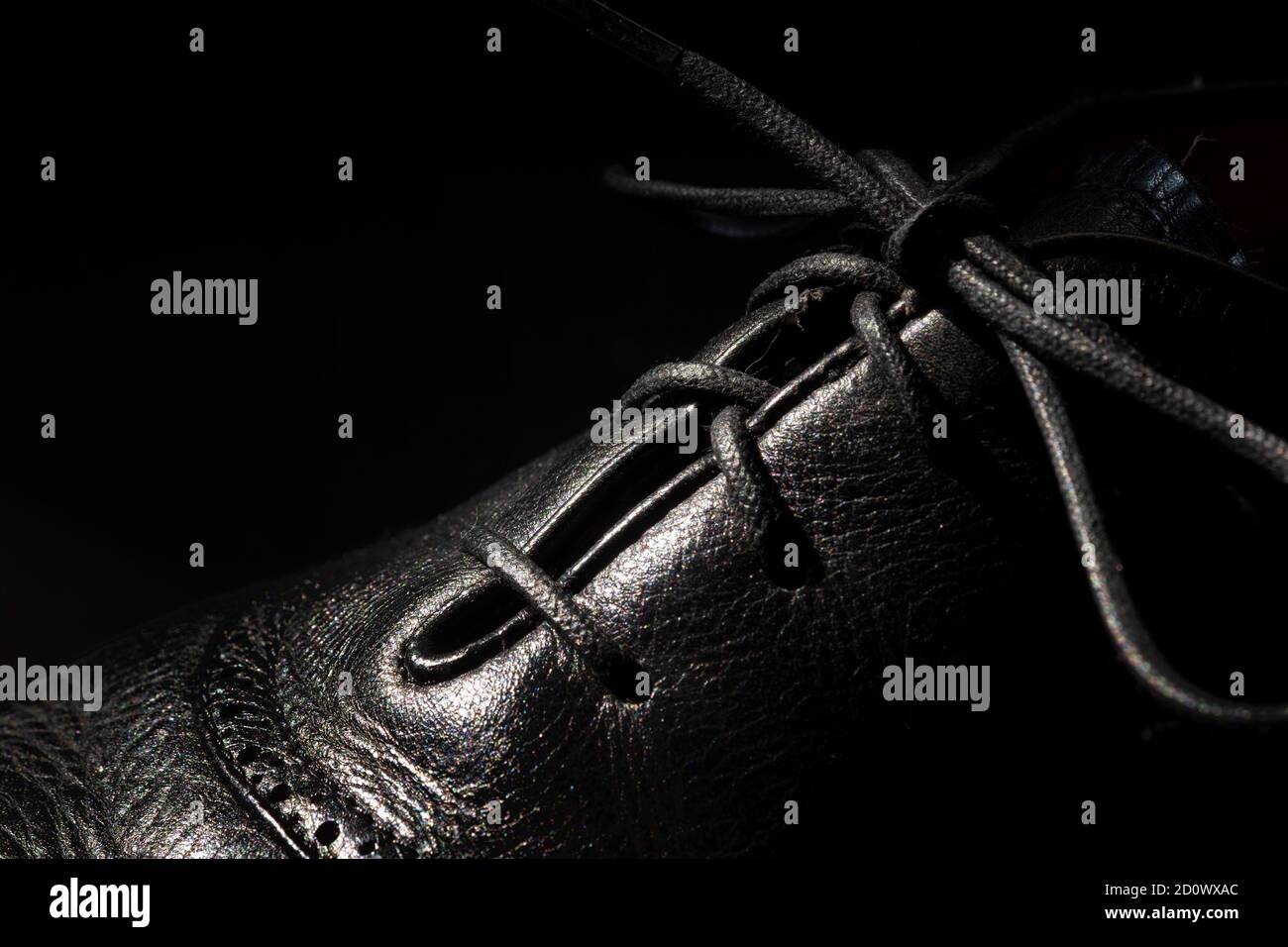 Primo piano di una scarpa da vestito nera da uomo con il pizzo legato in un arco. Foto Stock