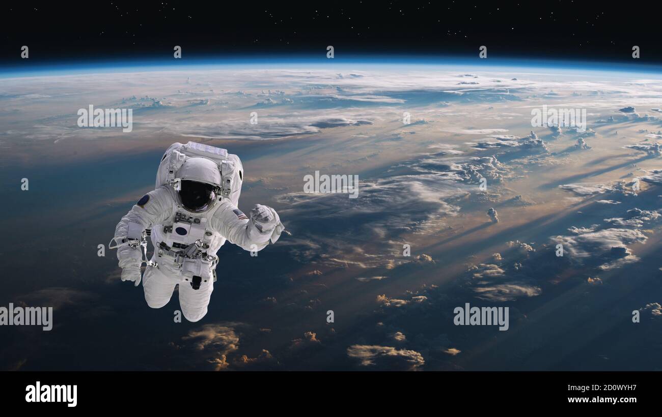 Astronauta che cammina nello spazio con sfondo terrestre. Elementi di questa immagine forniti dalla NASA. Foto Stock
