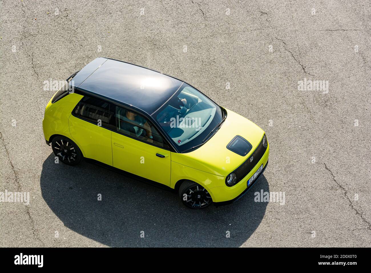 Praga, repubblica Ceca - 02 Ottobre 2020. Giallo verde elettrico Honda e - guida sulla strada catrame - vista sul tetto nero di uccelli prospettiva Foto Stock