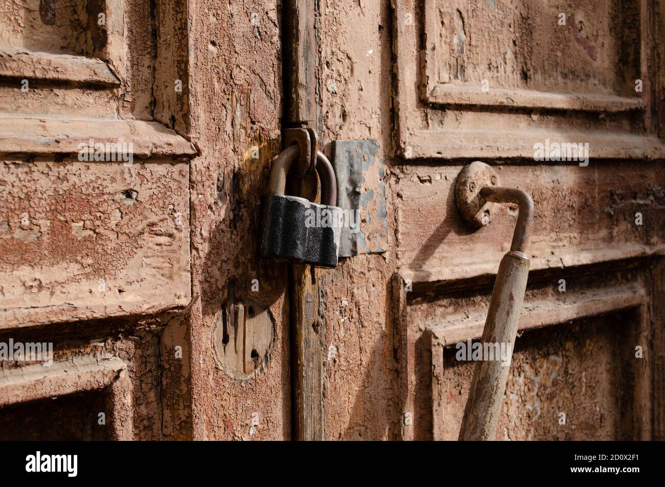 La serratura sulla vecchia chiusura della porta di legno. Ruggine sul blocco in metallo. Sbucciando la vernice marrone sulla vecchia porta. Tessitura antica. Foto Stock