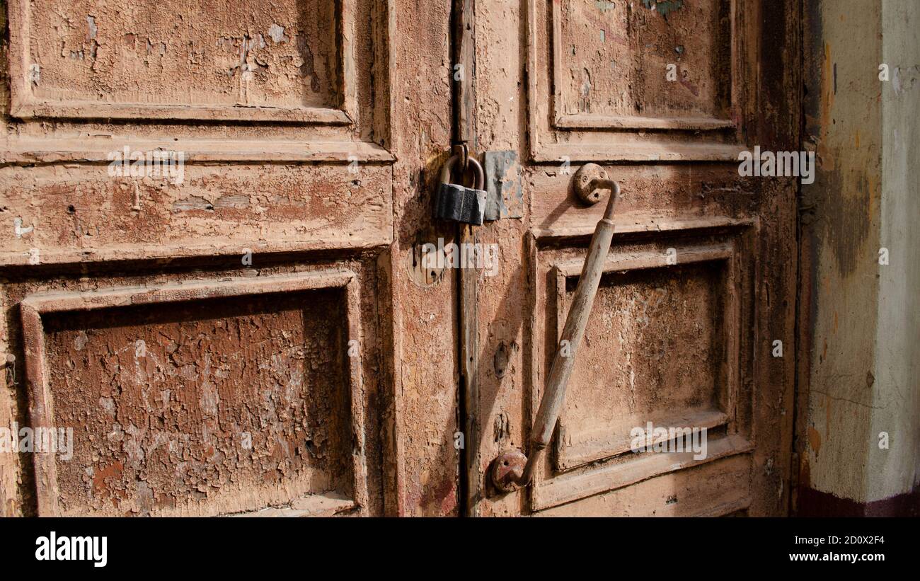 La serratura sulla vecchia chiusura della porta di legno. Ruggine sul blocco in metallo. Sbucciando la vernice marrone sulla vecchia porta. Tessitura antica. Foto Stock