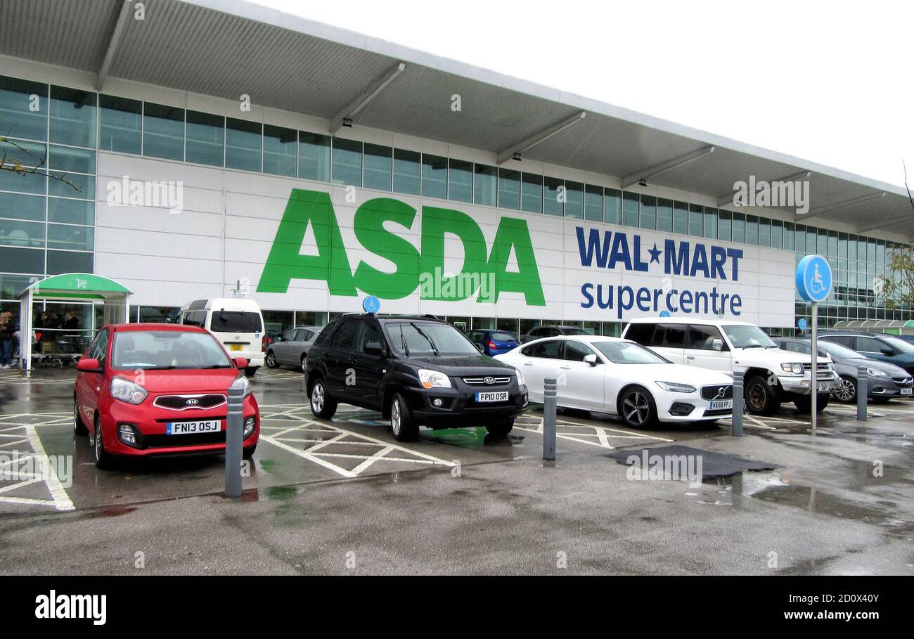 Le automobili sono viste parcheggiate fuori di un grande Asda ed ex proprietario del Walmart supercentres.UK terzo più grande catena del supermercato Asda è stata venduta dal relativo proprietario degli Stati Uniti Walmart.i fratelli Bilionaire Mohsin & Zuber Issa e la ditta di equità privata TDR capitale ha vinto la guerra d'offerta in un affare £6,8 miliardo. I fratelli Issa con sede a Blackburn possiedono EG Group, che hanno costruito da un'unica stazione di servizio nel 2001 a più di 6,000 siti in tutto il mondo e un fatturato annuo di £20 miliardi. Sarà la prima volta che Asda sarà in proprietà britannica da oltre 20 anni. Foto Stock