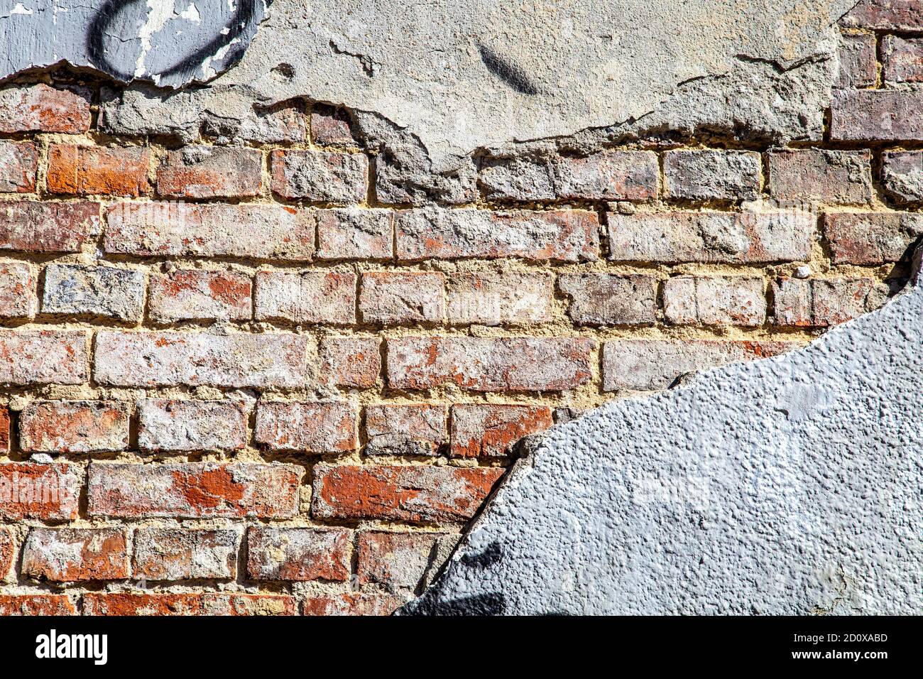 Stucco cemento che si stacca da una parete di mattoni rossi, facciata di un edificio nel quartiere Praga di Varsavia, Polonia Foto Stock