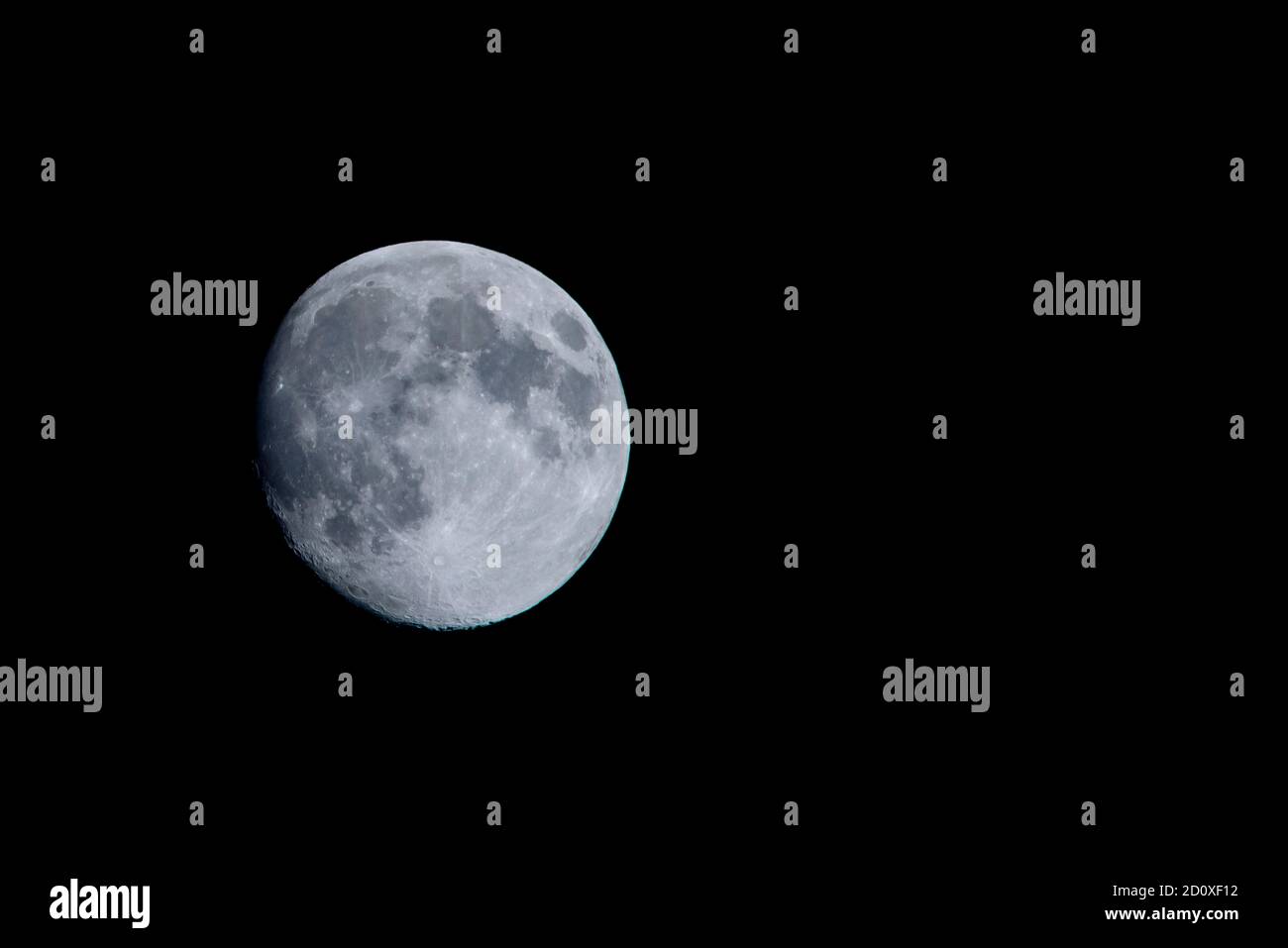 Luna quasi piena su un cielo nero scuro Foto Stock