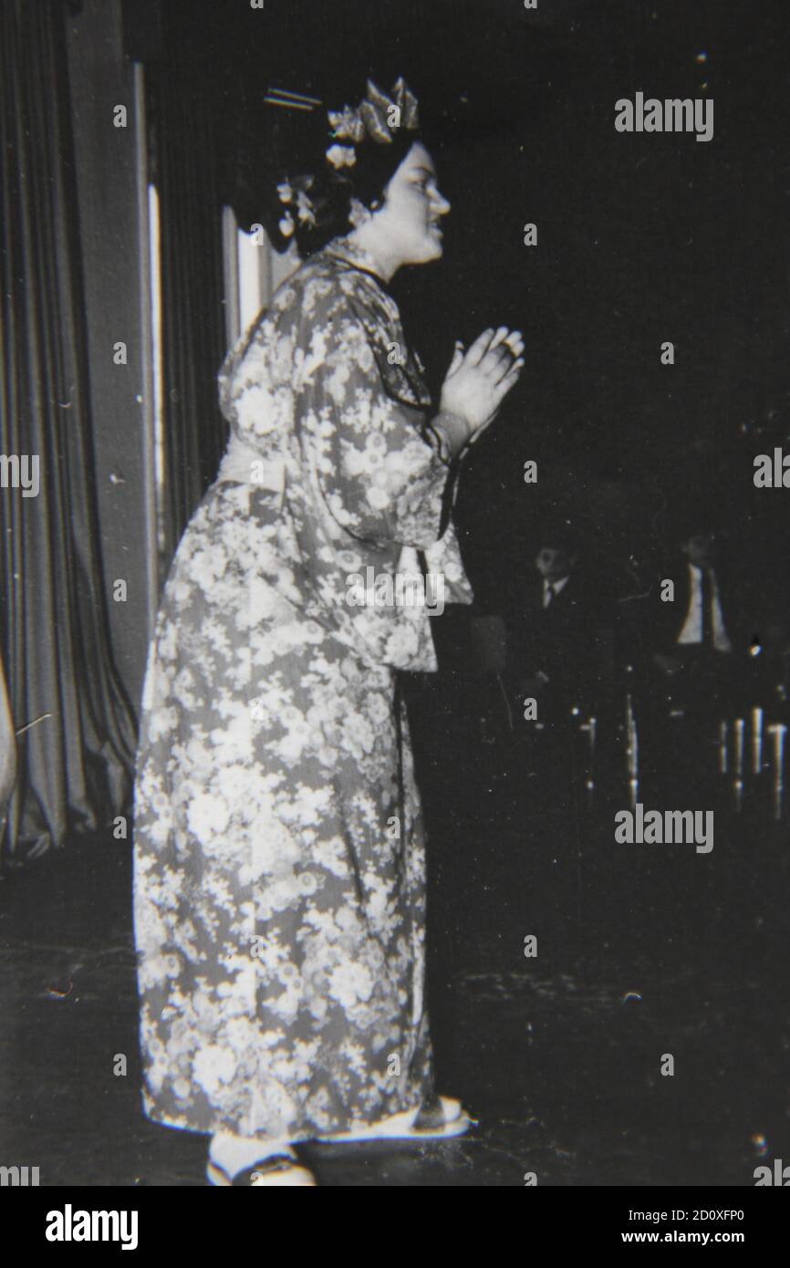 Bella fotografia in bianco e nero degli anni '70 di una ragazza di festa vestita come geisha giapponese per una festa di masquerade. Foto Stock