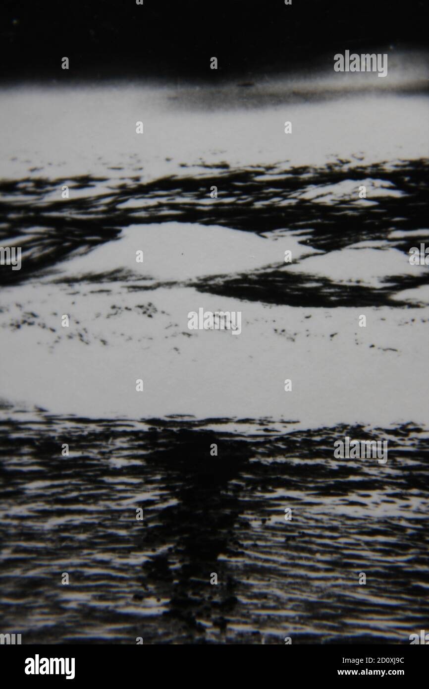 Bella fotografia in bianco e nero degli anni '70 di una bellissima spiaggia e di enormi onde. Foto Stock