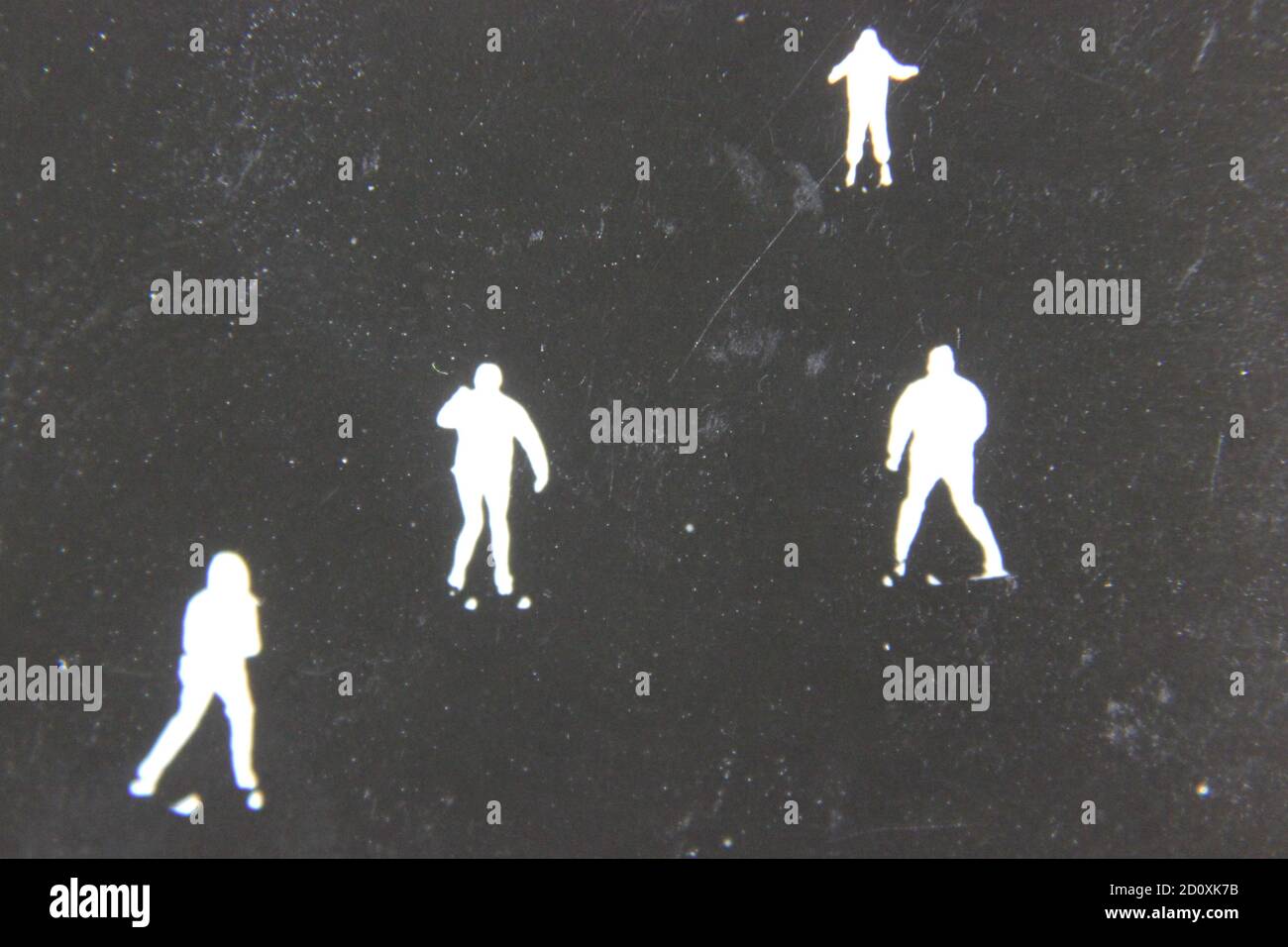 Fine anni '70 vintage profilo in bianco e nero fotografia di sciatori sulla collina di sci nei loro completi abiti da sci e sci che scende la collina. Foto Stock