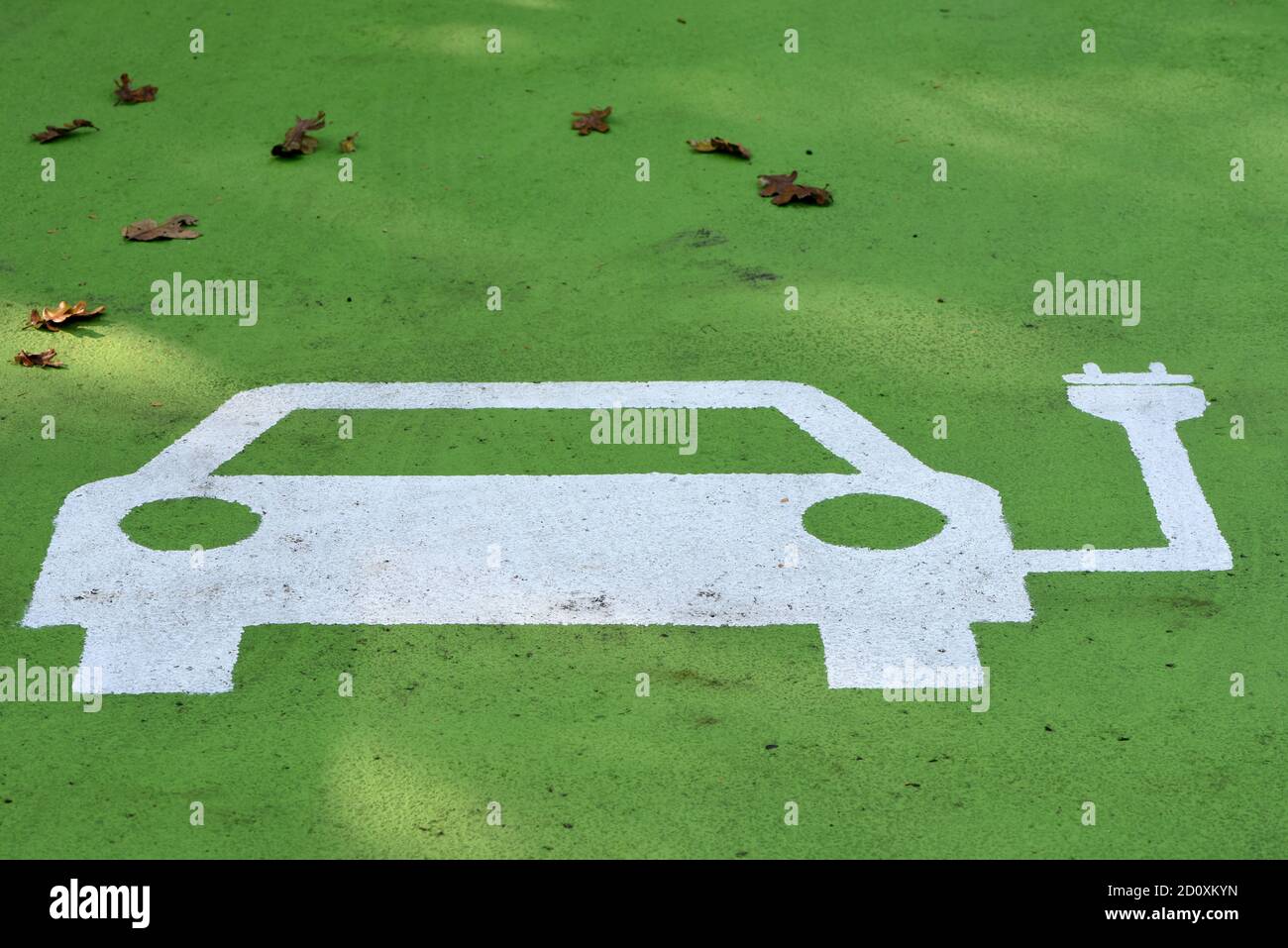 Un simbolo dipinto su un punto di parcheggio per un'elettricità Stazione di carica del veicolo (EV) Foto Stock