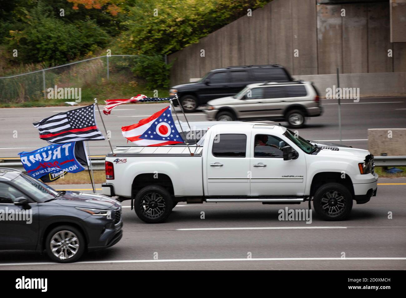Il partecipante alla Trump Parade vola più bandiere dalla parte posteriore del proprio camion, compresa una bandiera dell'Ohio. I sostenitori di Trump si sono mostrati in gran numero sulla i-270 in un evento chiamato Trump Parade. Durante questo evento, i sostenitori di Trump hanno guidato la i-270, l’autostrada che circonda Columbus, Ohio, dalle 10:00 a mezzogiorno per mostrare il sostegno al presidente Donald Trump durante la stagione elettorale. I partecipanti alla Trump Parade hanno guidato nel vicolo centrale dell'autostrada, e sono stati accolti con il sostegno dei cavalcavia e dei compagni di guida. L'evento ha ricevuto un'opposizione minima. Foto Stock