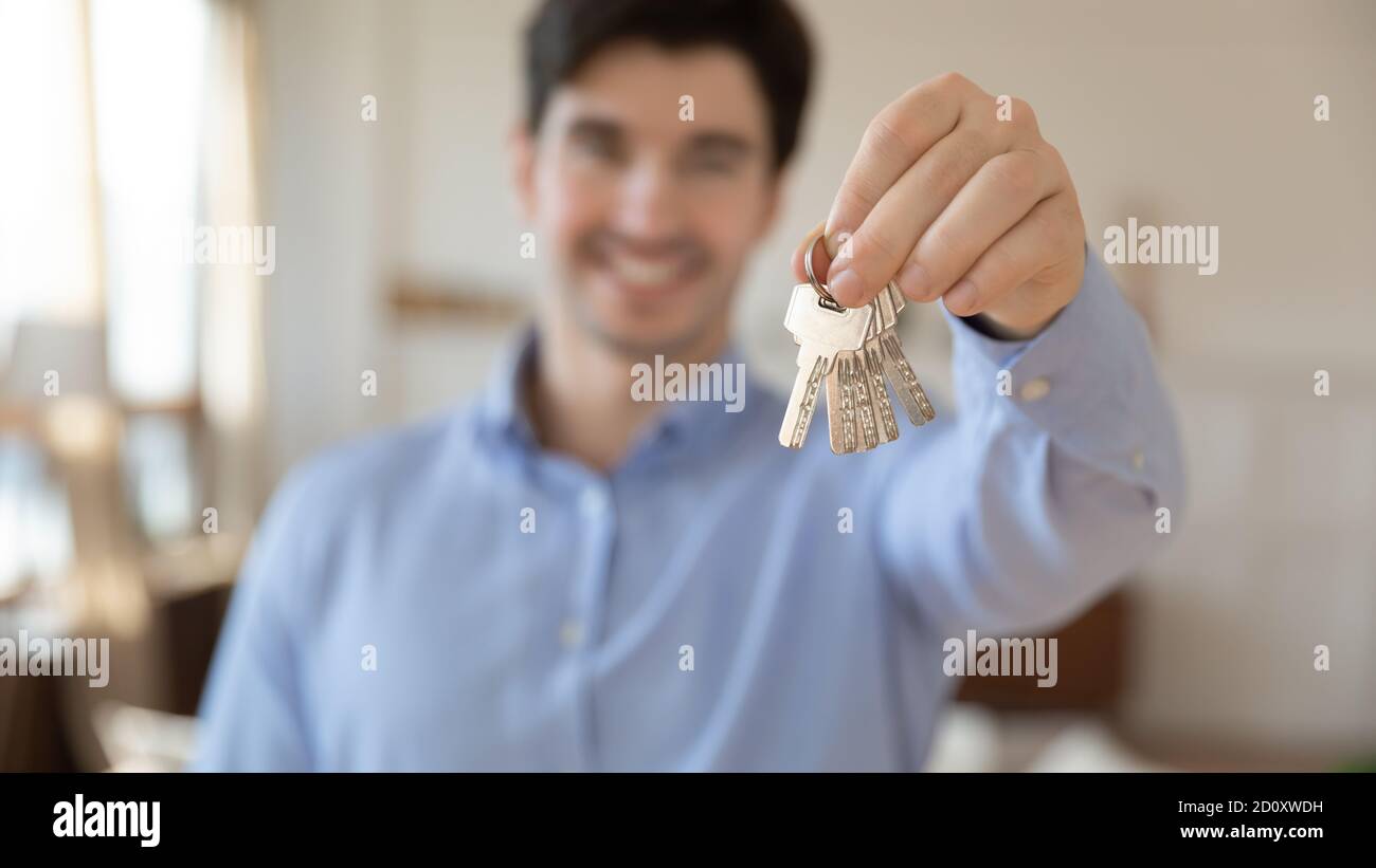 Sorridente agente immobiliare che vi dà le chiavi da appartamento acquistato Foto Stock