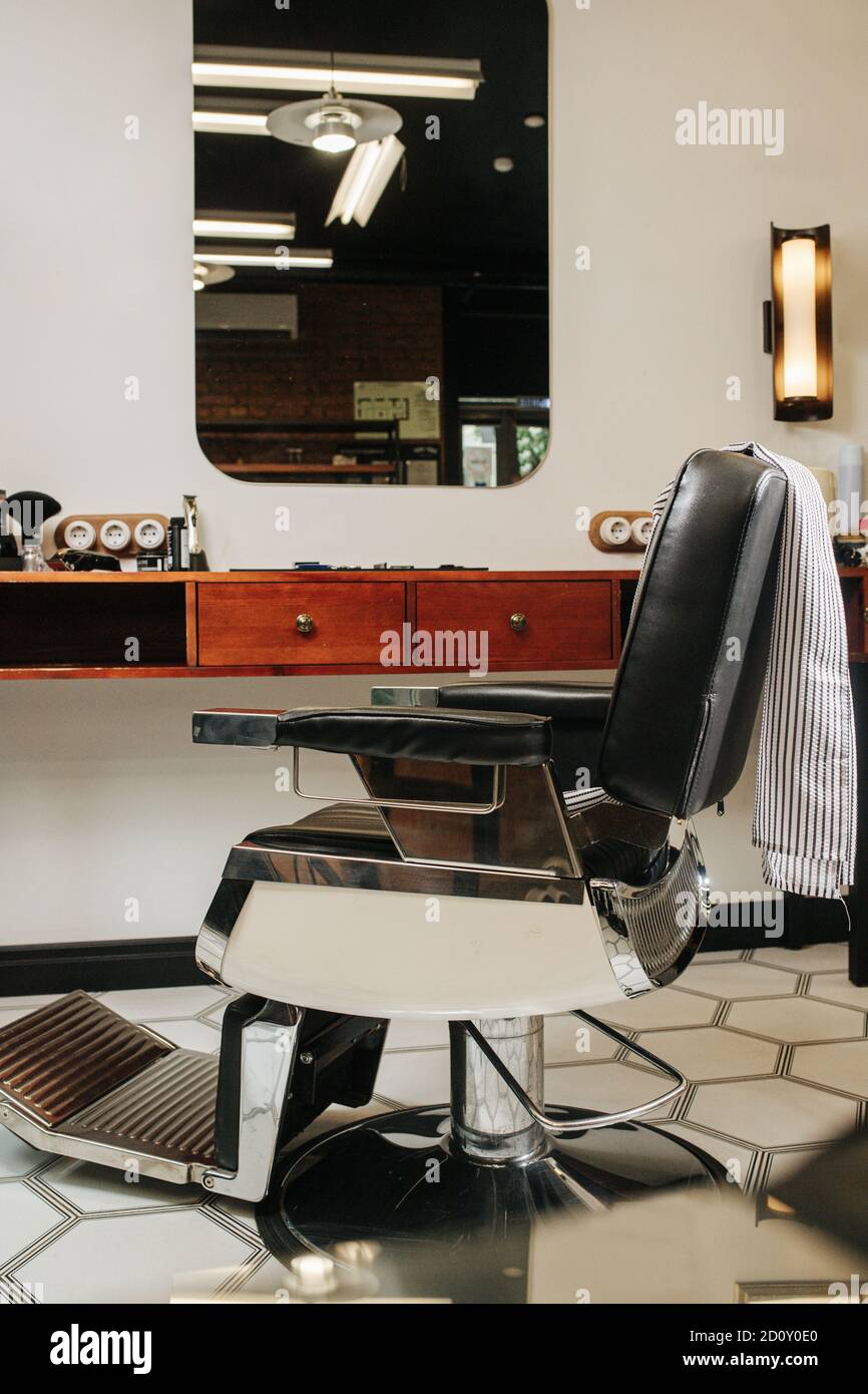 Comoda sedia estetista in un barbiere su pavimento a motivi esagonali Foto  stock - Alamy