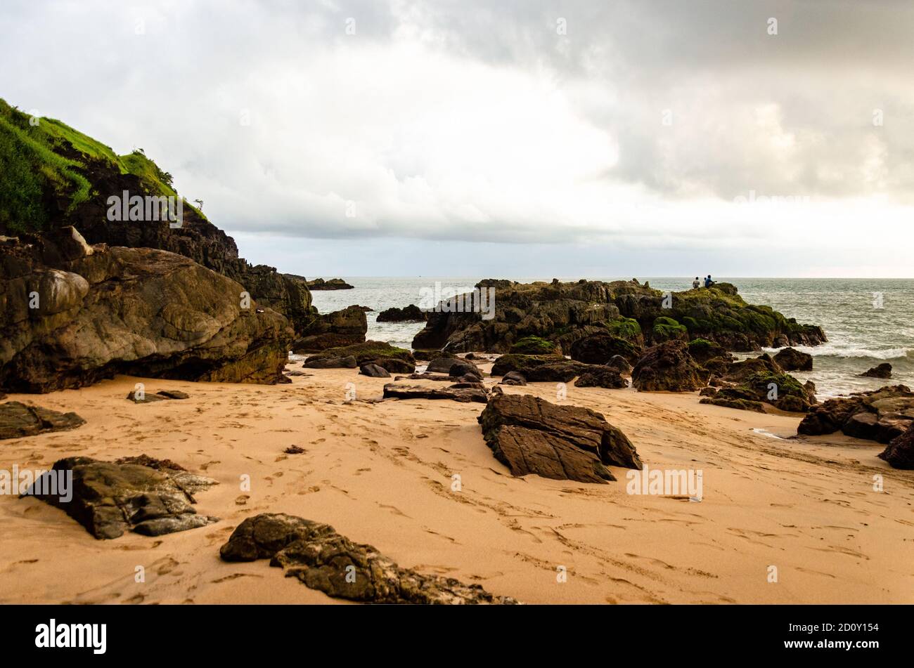 Pescatori che pescano lontano, seduti sulla roccia a Kakolem Beach, Canacona, Goa, India Foto Stock