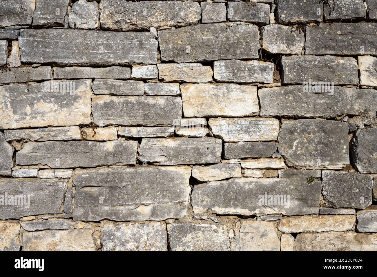 Sfondo di un vecchio e logoro muro di pietra naturale Foto Stock