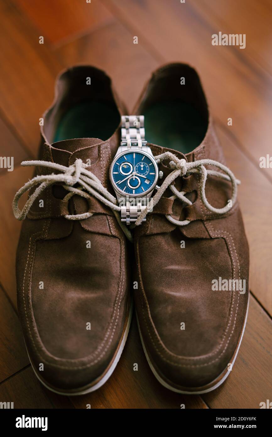 Orologio da polso marrone con lacci in pelle scamosciata da uomo con quadrante blu. Foto Stock