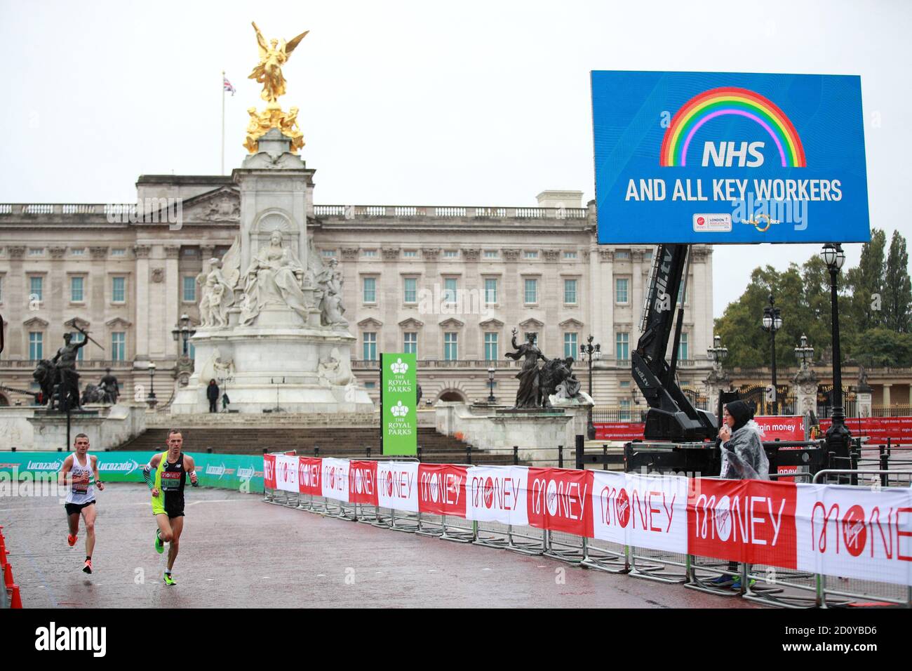 Gli atleti passano un cartello di ringraziamento per il personale NHS e i tastieristi durante la gara Elite Men's durante la Maratona di Londra Virgin Money intorno al St James' Park. Foto Stock