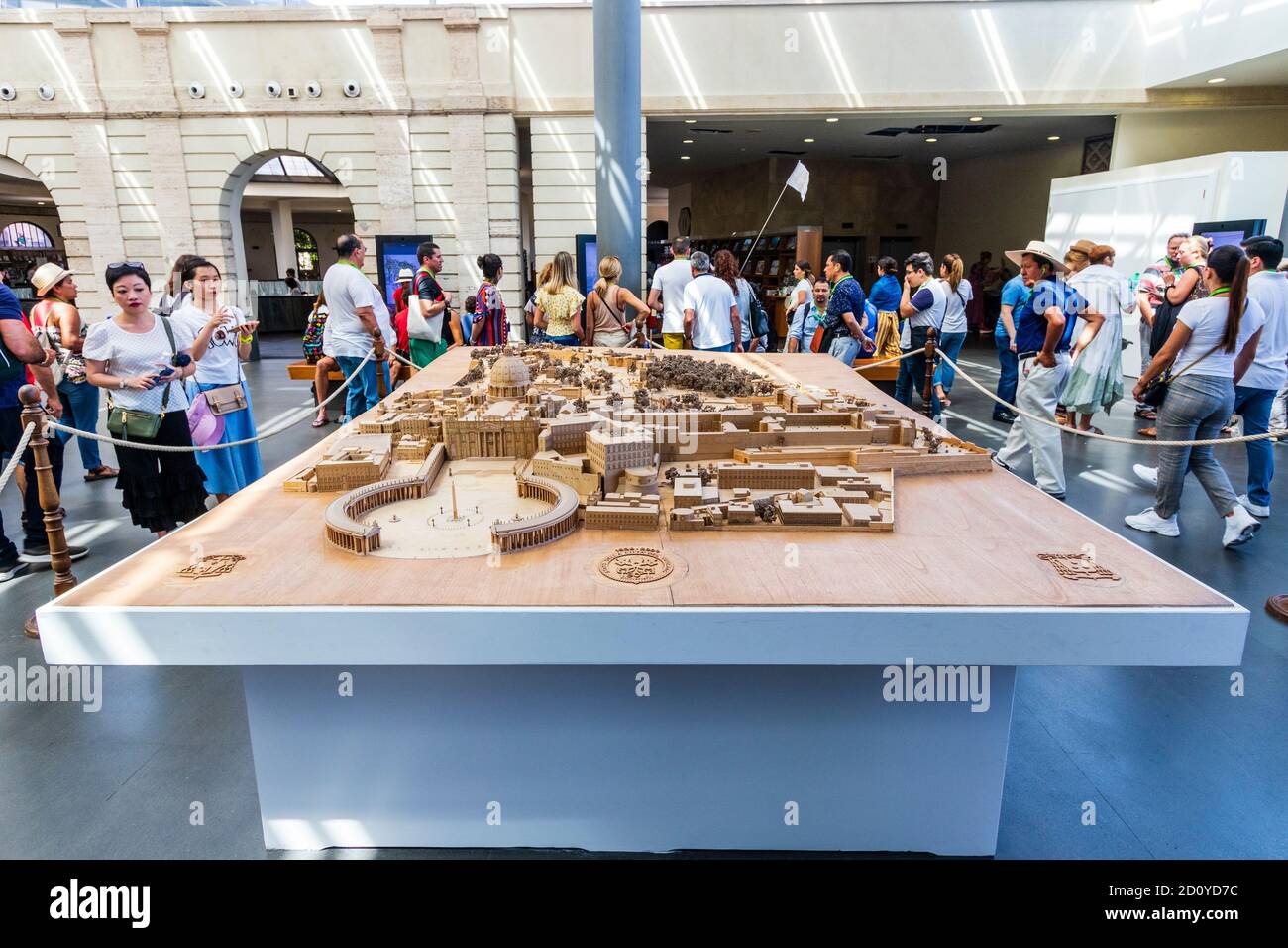 Grande modello in legno dello stato del Vaticano all'ingresso dei Musei Vaticani con i turisti che passeggiano. St peters all'avanguardia del modello. Foto Stock