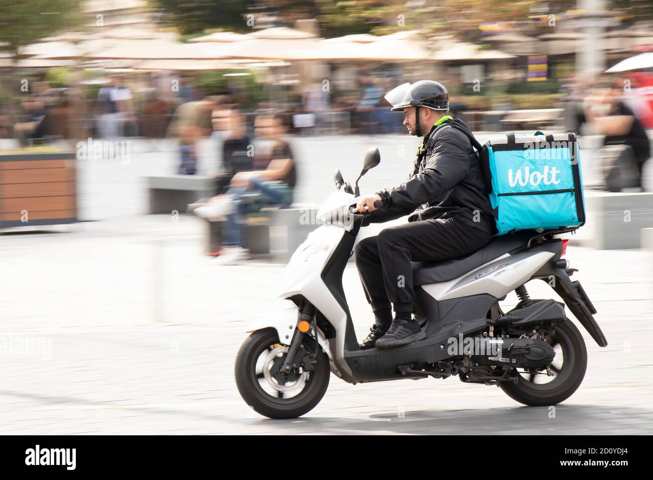 Belgrado, Serbia - 02 ottobre 2020: Corriere che lavora per il servizio di consegna di cibo della città di Wolt che guida una moto scooter in strada della città Foto Stock