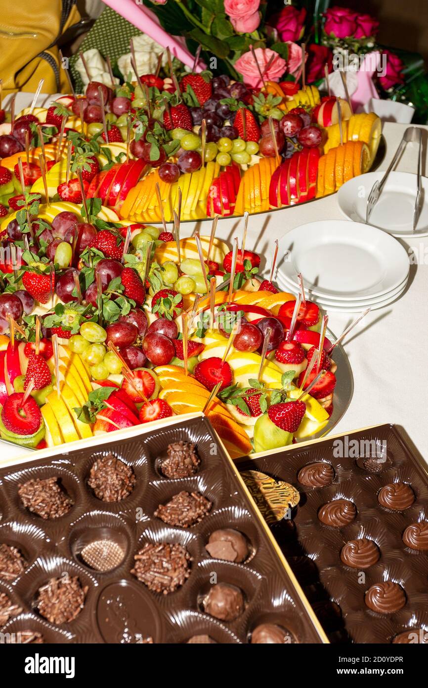 Autentico buffet, frutta fresca assortita, frutti di bosco e agrumi. Illuminazione d'atmosfera mattutina, spot alla moda con messa a fuoco morbida. Foto Stock