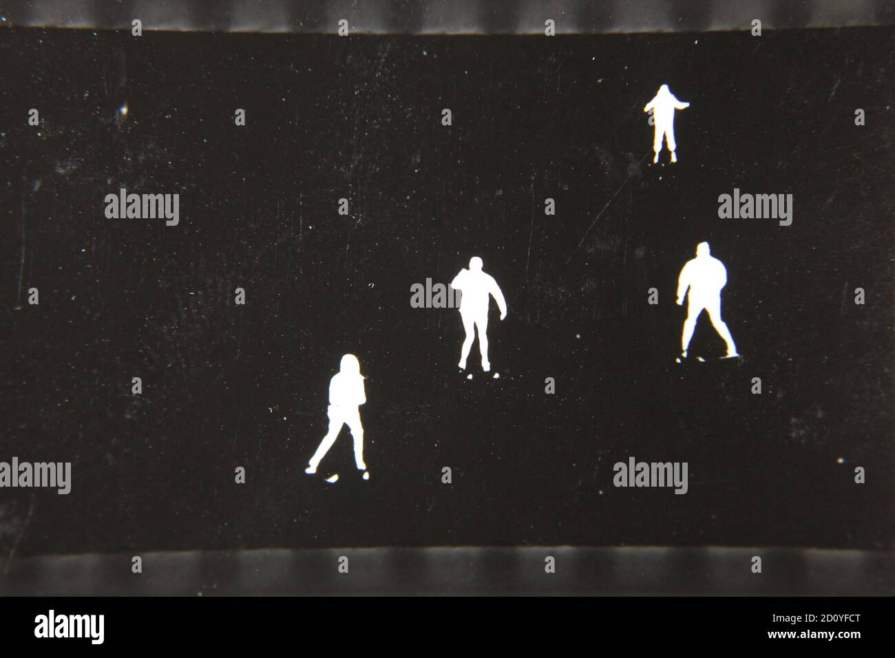 Fine anni '70 vintage profilo in bianco e nero fotografia di sciatori sulla collina di sci nei loro completi abiti da sci e sci che scende la collina. Foto Stock