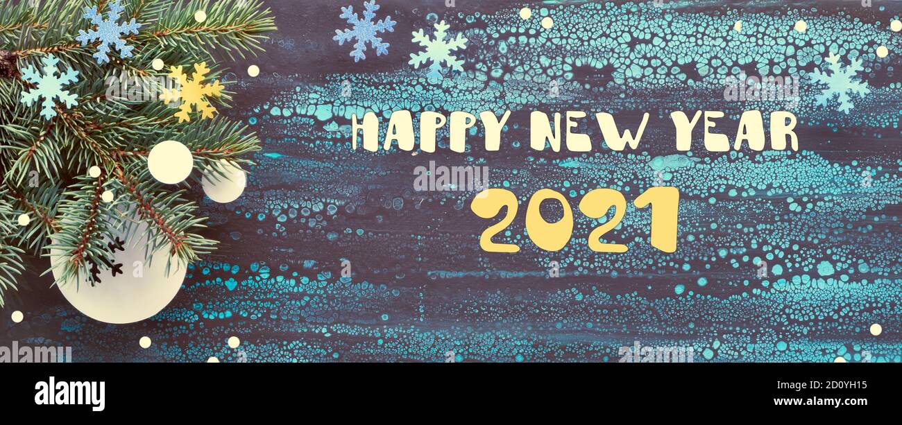 Sfondo natalizio con ramoscelli di abete e decorazioni in carta su sfondo panoramico scuro. Texte sur Happy New Year 2021. Foto Stock