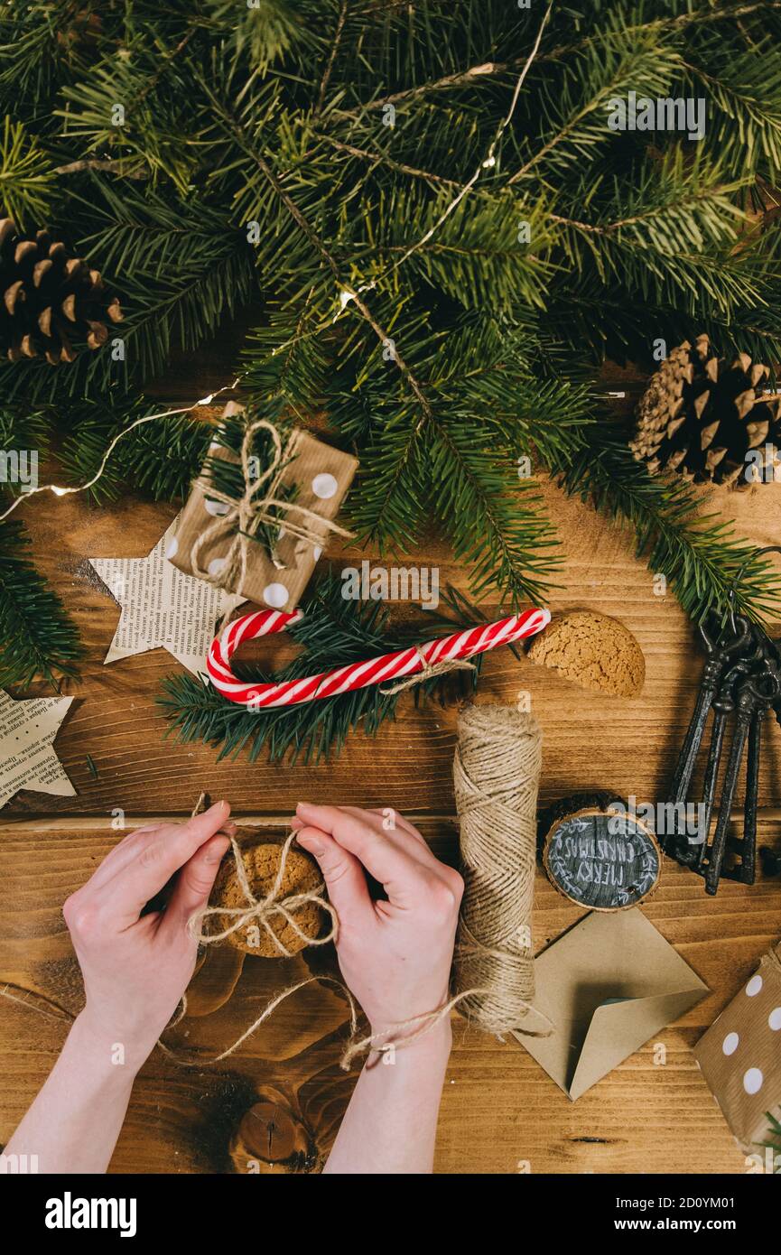 Le mani della donna si preparano per Natale. Artigianato natalizio, coni di pino Foto Stock