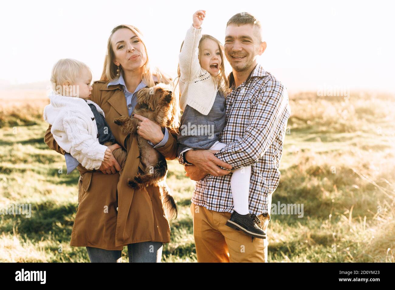 felice famiglia che gioca nel campo verde Foto Stock