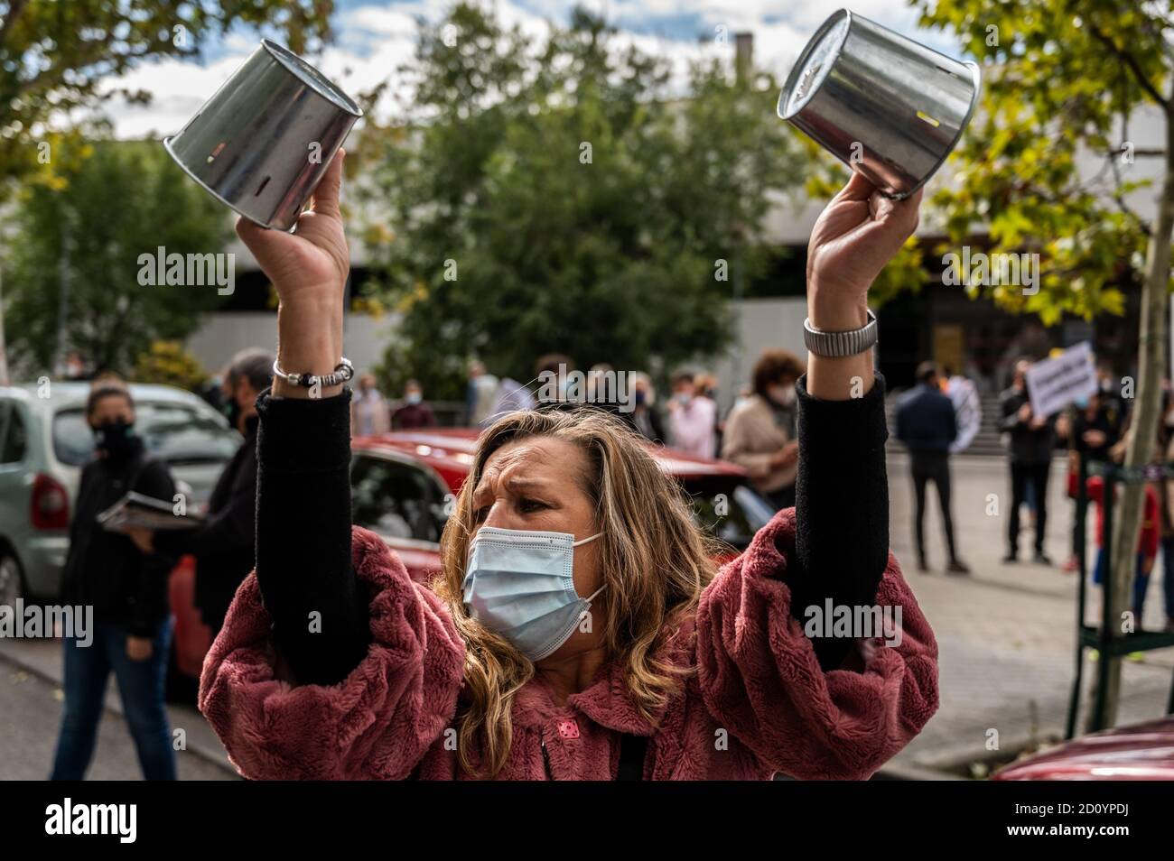 Madrid, Spagna. 04 ottobre 2020. Una donna che fa dei vasi da rumore come residenti del quartiere Vallecas di Madrid protesta di fronte alla Comunità regionale il Parlamento chiede le dimissioni del presidente regionale Isabel Diaz Ayuso per la negligente gestione della crisi del coronavirus e a sostegno del sistema sanitario pubblico. Credit: Marcos del Mazo/Alamy Live News Foto Stock