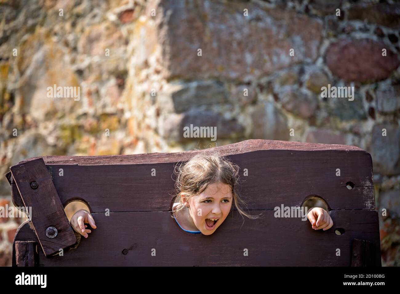 Primo piano di un bambino intrappolato in un dispositivo di tortura medievale Foto Stock