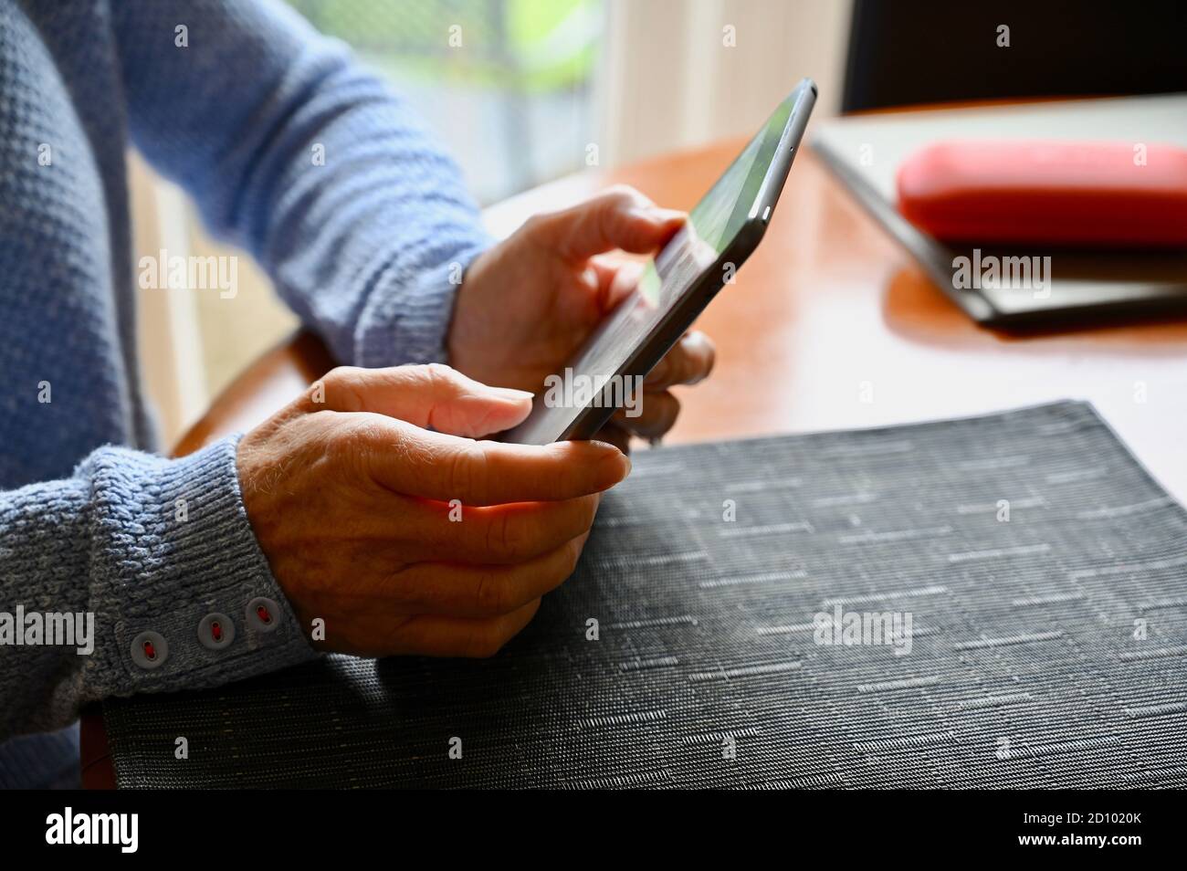 Primo piano di una donna anziana che utilizza il suo tablet Apple iPad . Foto Stock