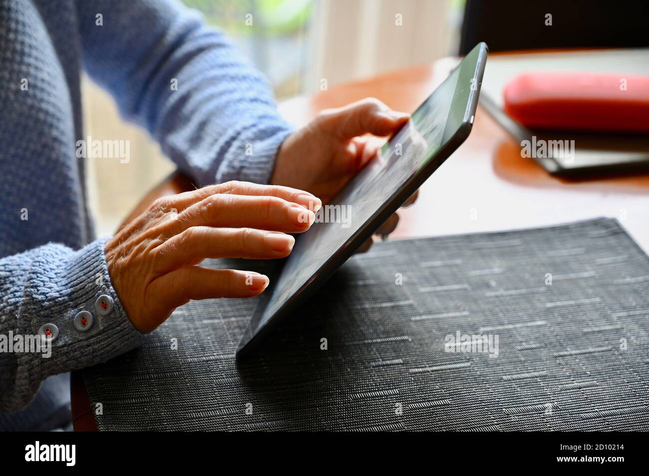 Primo piano di una donna anziana che utilizza il suo tablet Apple iPad . Foto Stock