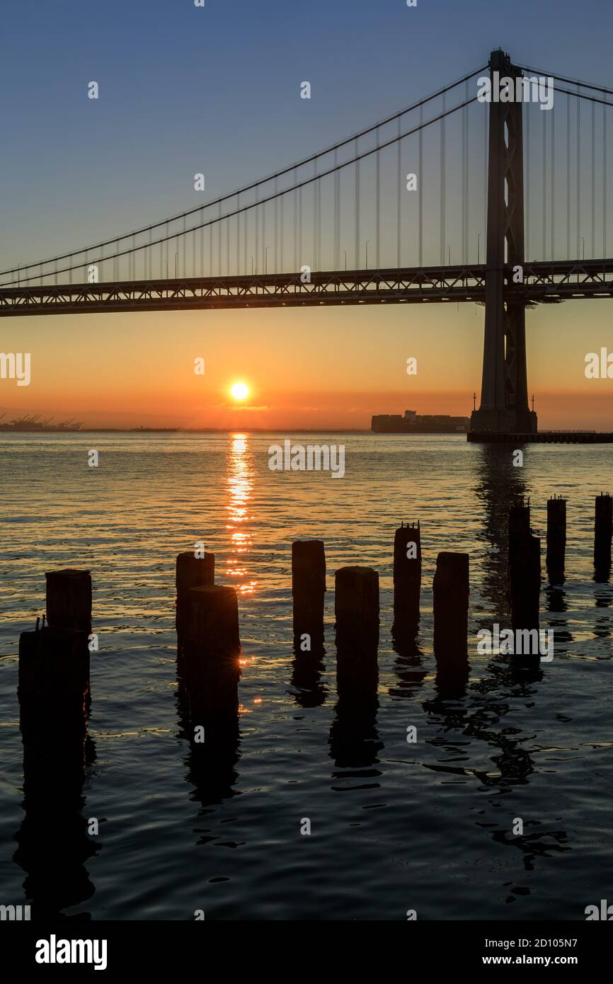 Sole che sorge sul Bay Bridge Foto Stock