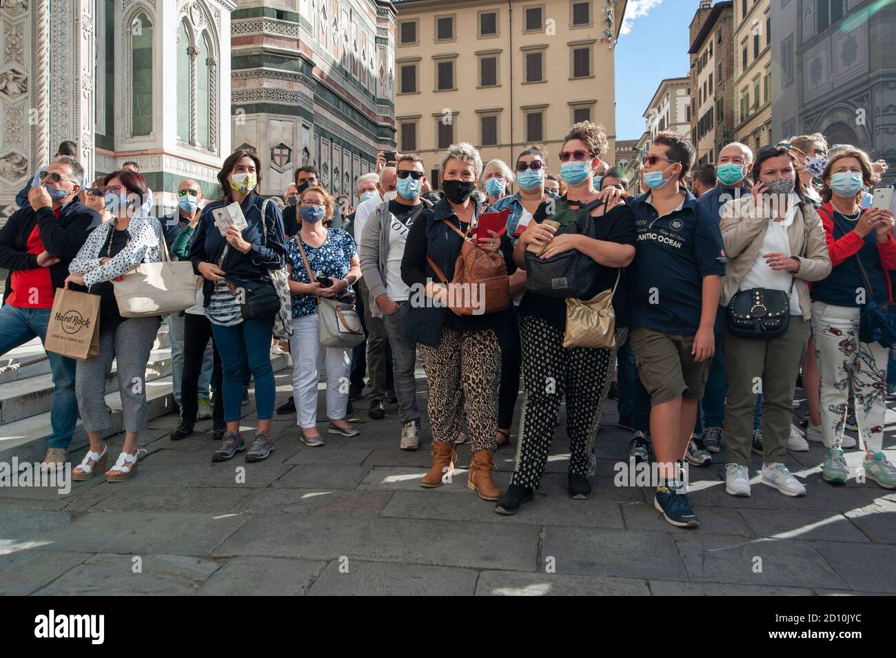 Firenze, Italia - 2020 settembre 26: Turisti (persone non identificate) che indossano maschere facciali e scatta foto con telefono in strada, durante Coronavirus. Foto Stock