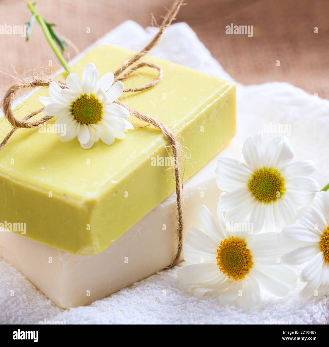 Saponi camomilla fatti in casa. Vista in primo piano delle saponette di colore bianco e giallo realizzate a mano. Prodotti cosmetici naturali salutari a base di erbe Foto Stock