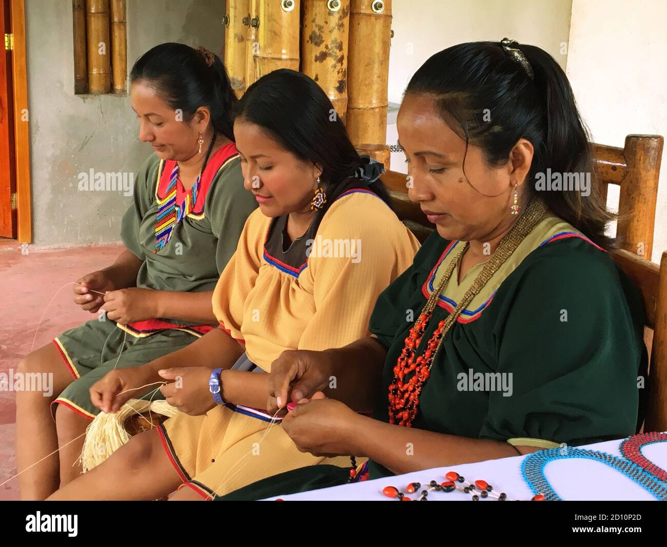 Nueva Loja, Sucumbios / Ecuador - 2 settembre 2020: Gruppo di tre donne indigene di nazionalità Cofan che tessono artigianato nella loro casa ad Amaz Foto Stock