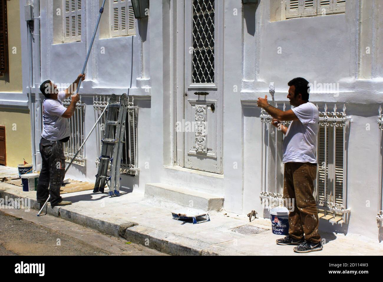Uomini che dipingono la parete esterna di una casa - Atene, Grecia, 6 maggio 2020. Foto Stock