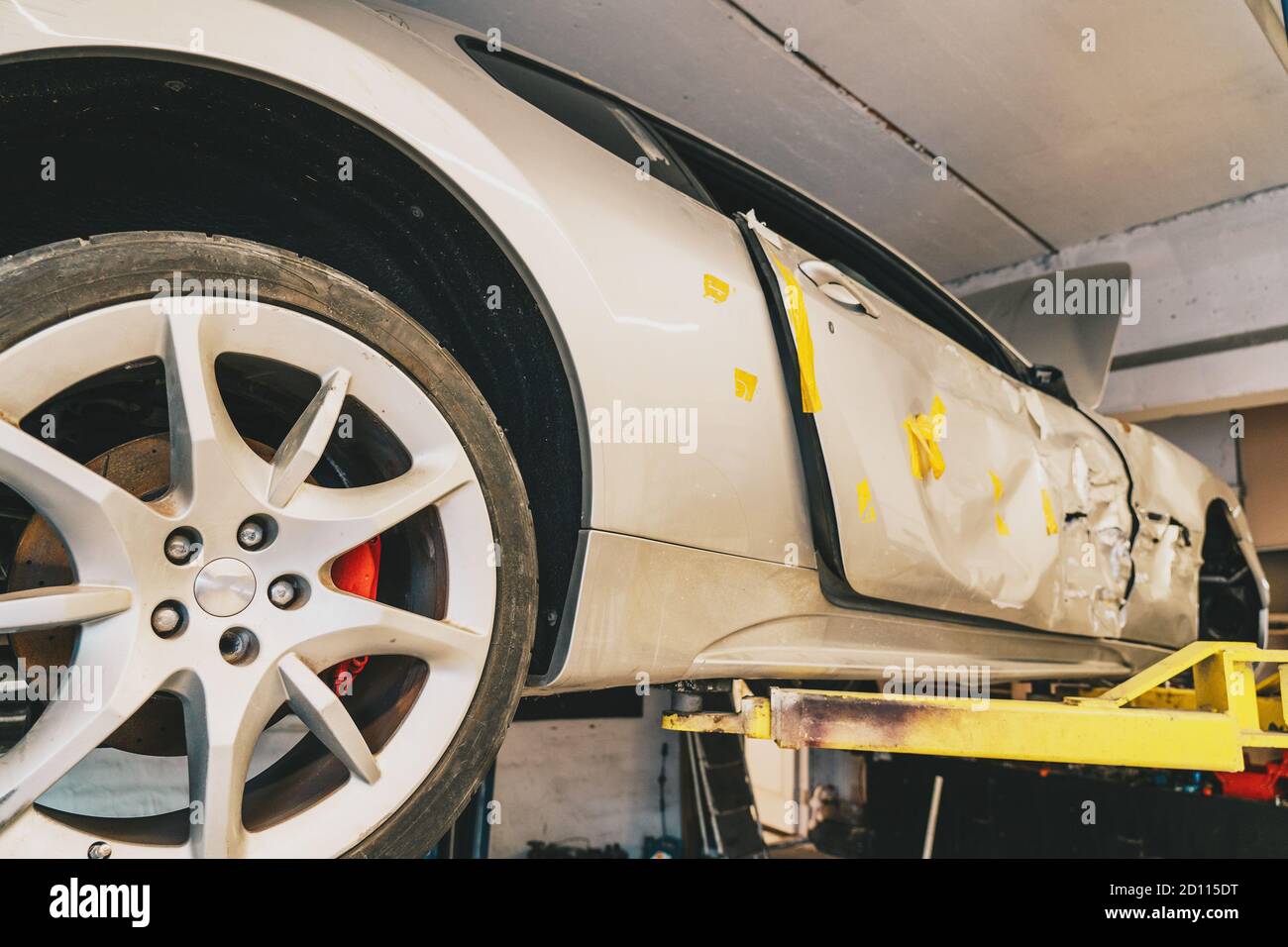 Auto sportiva rotta o danneggiata dopo un incidente stradale o un incidente in officina di riparazione, primo piano. Foto Stock