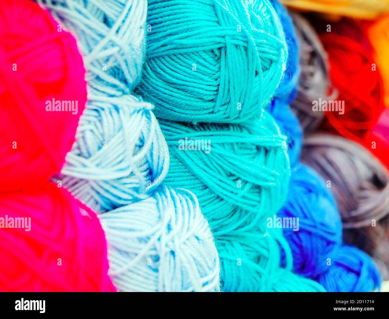 Matasse di filati di lana di diversi colori. Foto a schermo intero con messa a fuoco centrale. Banco di vendita Foto Stock