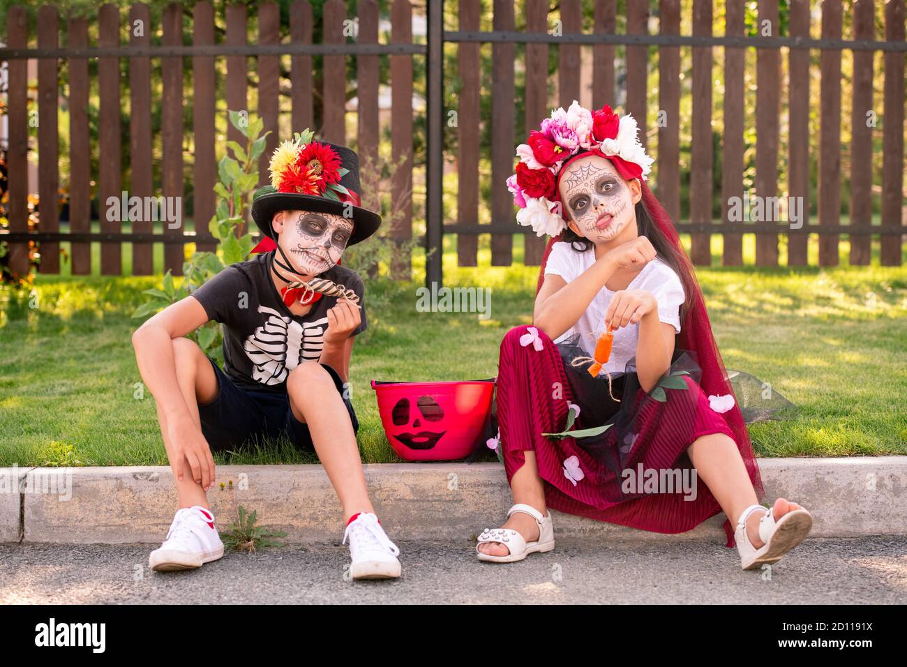 Divertenti piccoli amici in costumi di Halloween seduti su strada parte  anteriore della telecamera Foto stock - Alamy