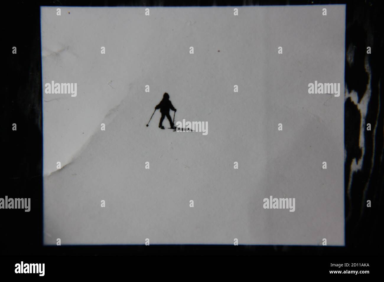Fine anni '70 vintage profilo in bianco e nero fotografia di uno sciatore sulla collina di sci nel suo completo sci vestito e sci scendendo la collina. Foto Stock