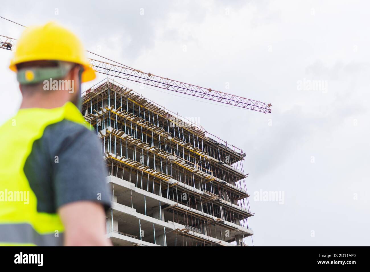 Un ingegnere che posa di fronte alla costruzione di un edificio è funzionamento di Foto Stock